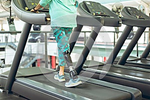 Disabled active senior woman exercising on treadmill in fitness studio