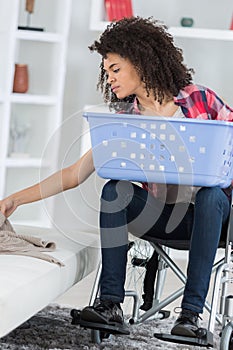 Disabled african amercian beautiful woman doing laundry at home