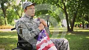 Disabled american veteran putting flag to heart remembering war, faith and pride