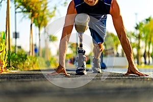 disabled athlete man with prosthetic leg starting to run at the beach on a treadmill outdoors at sunset