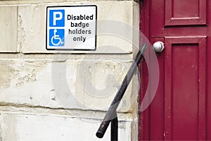 Disabled badge holders only sign and rail for accessible assistance to help old senior people and wheelchair users