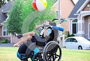 Disabled boy hitting ball with bat at park