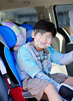 Disabled boy smiling while sitting in carseat