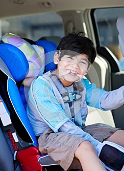 Disabled boy smiling while sitting in carseat photo