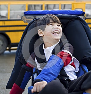 Disabled boy in wheelchair, by bus