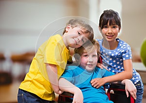 Disabled boy in wheelchair with friends in school classroom