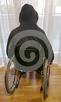 disabled boy in a wheelchair in his bedroom