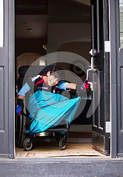 Disabled boy in wheelchair opening front door