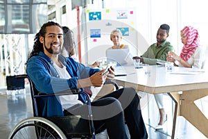 Disabled businessman with digital tablet looking at camera in conference room during meeting