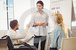 Disabled businessman pointing towards whiteboard