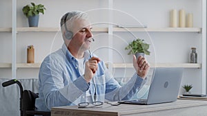 Disabled Businessman In Wheelchair Making Video Call On Laptop Indoor