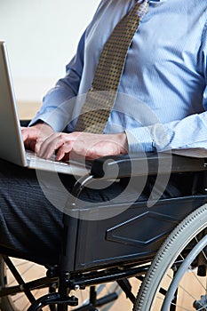 Disabled Businessman In Wheelchair Using Laptop