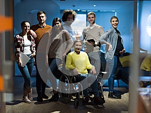 Disabled businesswoman in a wheelchair at the office with coworkers team