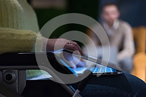 Disabled businesswoman in the wheelchair using her laptop while performing in co-working space. Disability and handicap concept.