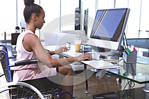 Disabled businesswoman working on computer at desk