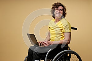 disabled caucasian man sits in a wheelchair with laptop