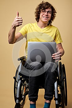 disabled caucasian man sits in a wheelchair with laptop