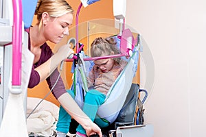 Disabled child being lifted into a wheelchair