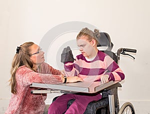 A disabled child in a wheelchair together with a voluntary care worker photo