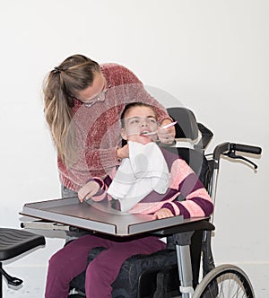 A disabled child in a wheelchair together with a voluntary care worker