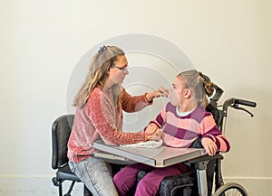 A disabled child in a wheelchair together with a voluntary care worker