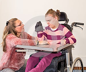 A disabled child in a wheelchair together with a voluntary care worker