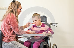 A disabled child in a wheelchair together with a voluntary care worker