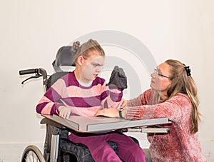 A disabled child in a wheelchair together with a voluntary care worker