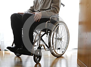 Disabled elderly in a wheelchair in the room