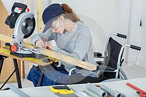 Disabled female worker in wheelchair in carpenters workshop photo