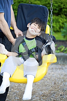 Disabled five year old boy in handicap swing