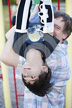 Disabled five year old boy on the monkey bars