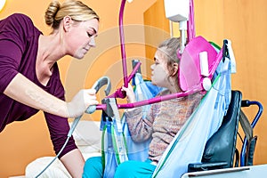 A disabled girl being lifted into a wheelchair