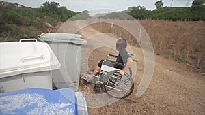 Disabled girl in wheel chair in everyday life doing recycling