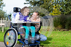 Disabled girl in a wheelchair relaxing outside