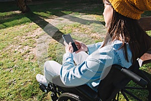 Disabled girl in a wheelchair using her mobile phone