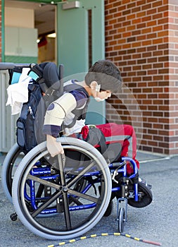 Disabled kindergartner in wheelchair on playground at recess photo