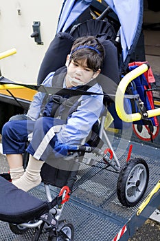 Disabled little boy on bus wheelchair lift