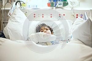 Disabled little boy lying sick in hospital bed