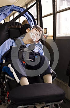 Disabled little boy in wheelchair on school bus