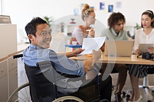 Disabled male executive holding graph paper in offce