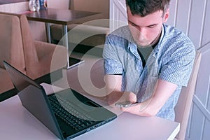 Disabled man with amputated stump hands typing message on mobile phone in cafe.