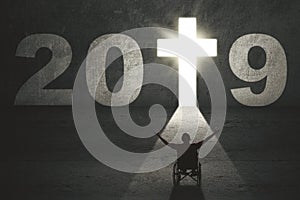 Disabled man with cross symbol and number 2019