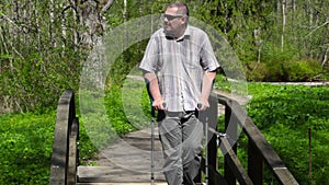 Disabled man with crutches walking on bridge