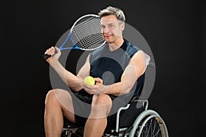 Disabled man holding racket and ball