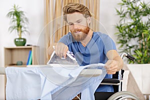 Disabled man ironing at home