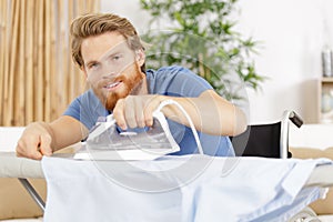 Disabled man ironing shirt