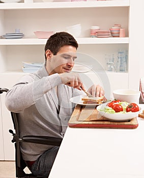 Disabled Man Making Sandwich In Kitchen