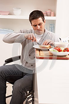 Disabled Man Making Sandwich In Kitchen