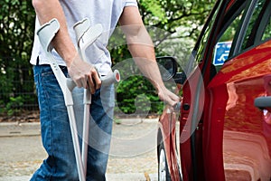 Disabled man opening door of a car